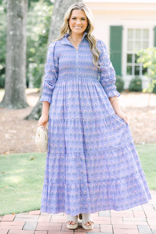 Plus size purple floral maxi dress with a smocked bodice, tiered skirt, and long sleeves.
