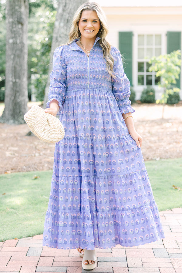 Plus size purple floral maxi dress with a smocked bodice, tiered skirt, and long sleeves.