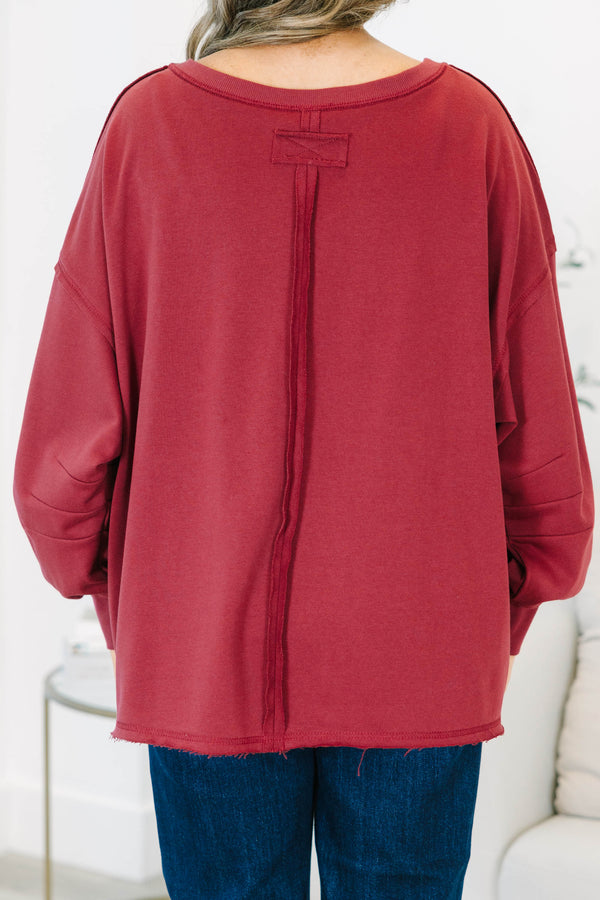 Plus Size burgundy V-neck pullover with long cuffed sleeves and a raw hemline.