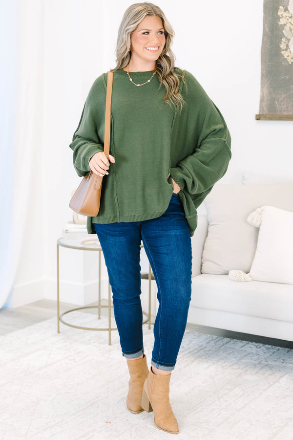 Plus size olive green oversized knit sweater with a flowy fit and exposed seam details.
