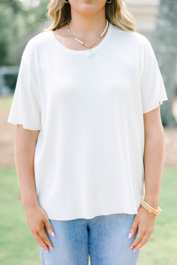 Plus size short sleeve, flowy knit sweater top with a round neck.