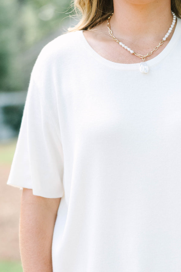 Plus size short sleeve, flowy knit sweater top with a round neck.