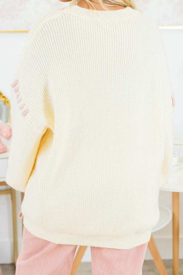 Chic Soul plus size clothing, ivory long sleeve sweater with pink robbin tied through the sweater around the neck, sleeves, and front