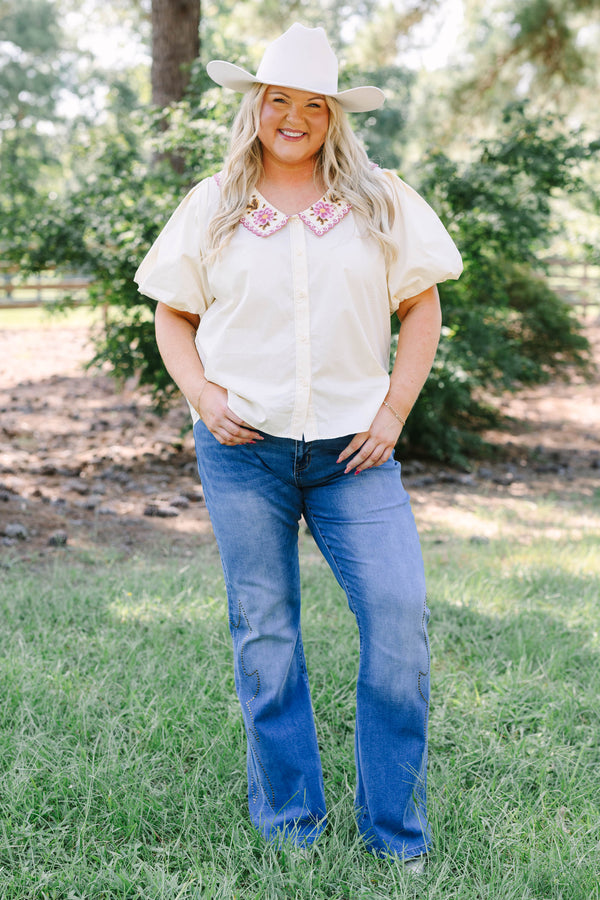 Plus Size medium wash flare jeans with studded embroidery along the outer side seams.