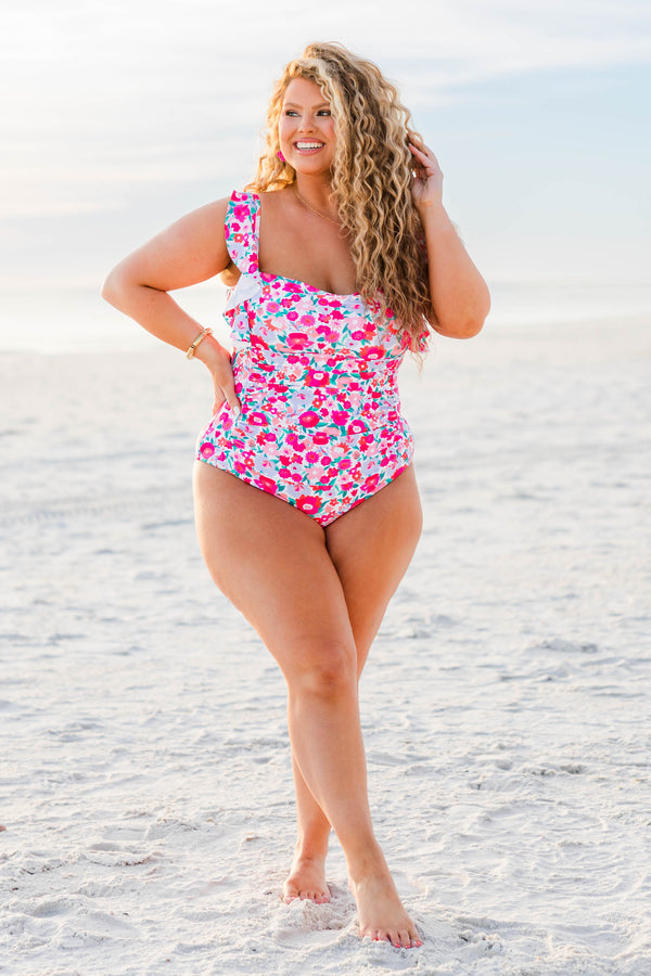 Plus Size one-piece swimsuit with pink floral print and ruffled shoulder straps.