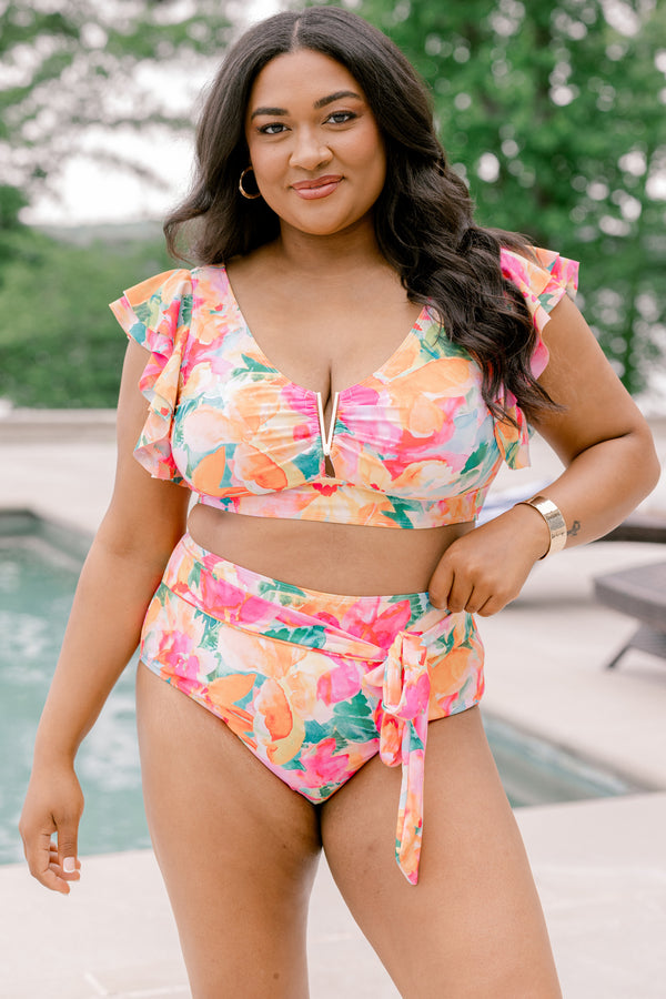 Chic Soul Plus Size Clothing, a pink, green, orange, and white water color floral print swim top with a gold V detail at center bust and ruffle sleeves