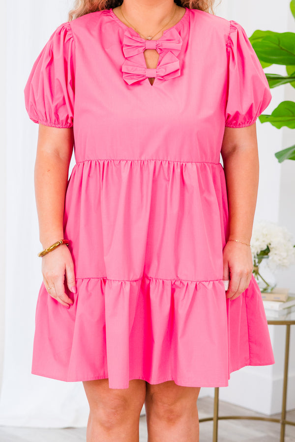Plus Size pink tiered babydoll dress with a bow-detailed v-neckline and bubble sleeves.
