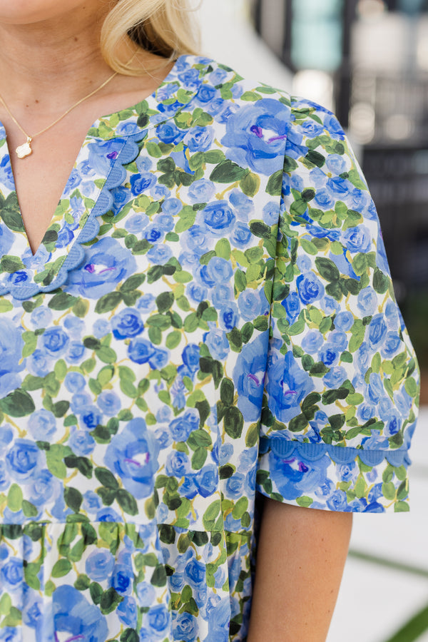 Chic Soul plus size clothing, blue short sleeve top with a green and blue floral pattern as well as scalloped stitching details along the bottom of the sleeves and along the v-neckline 