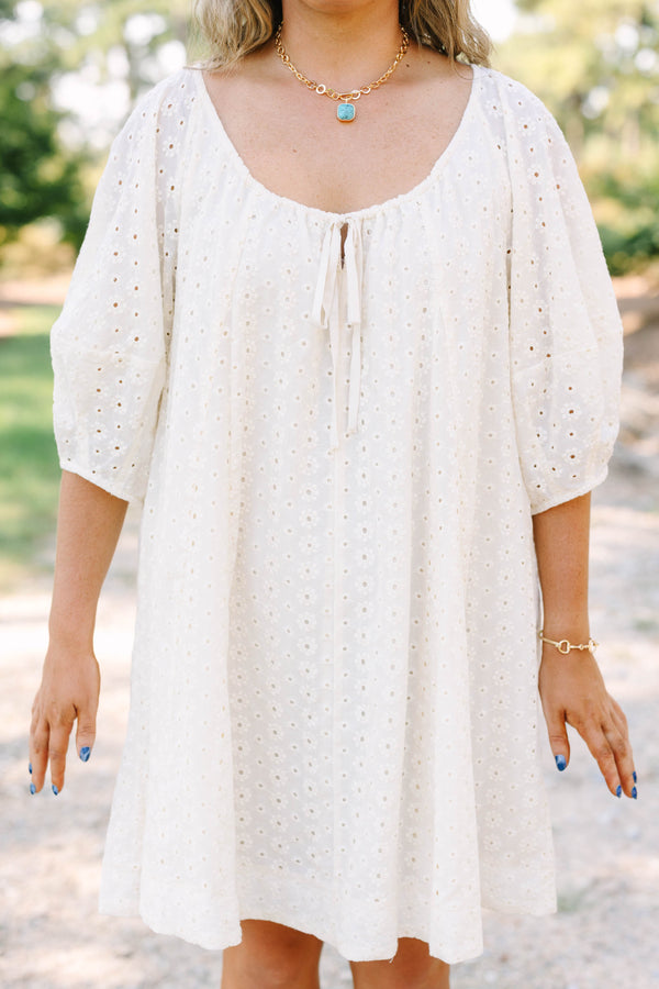 Plus Size ivory cotton eyelet dress with a scoop neckline, tie detail, and short puff sleeves.