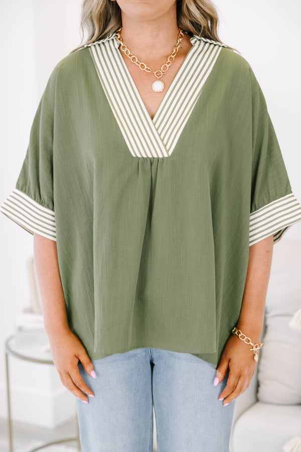 Plus size olive green flowy top with a striped V-neckline and matching striped sleeve cuffs.
