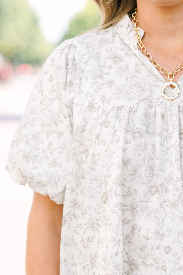 Plus Size cream floral blouse with a ruffled v-neckline and short elastic bubble sleeves.