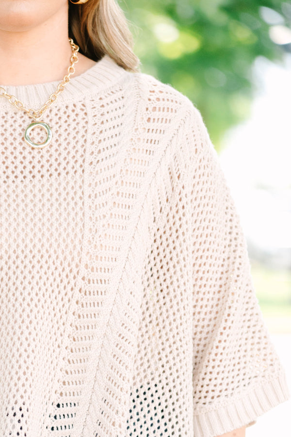 Plus size flowy oatmeal knit poncho sweater with a relaxed fit and textured stitch.