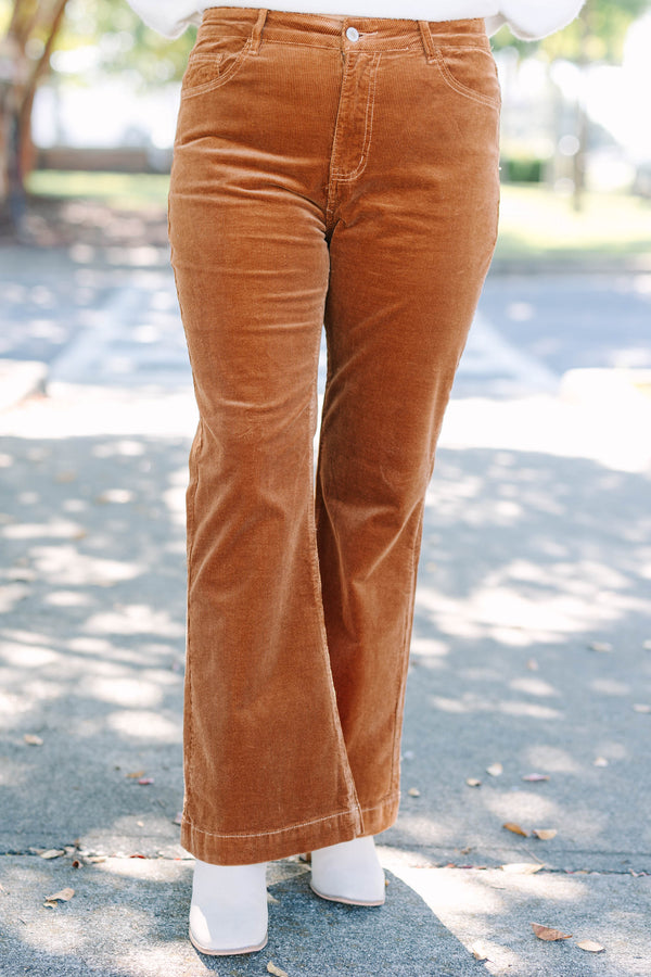 Plus size brown corduroy pants with a high-waisted, wide-leg silhouette and stretchy cotton fabric.