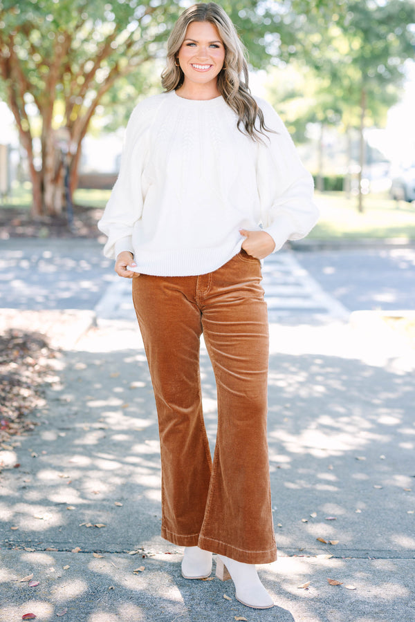 Plus size brown corduroy pants with a high-waisted, wide-leg silhouette and stretchy cotton fabric.