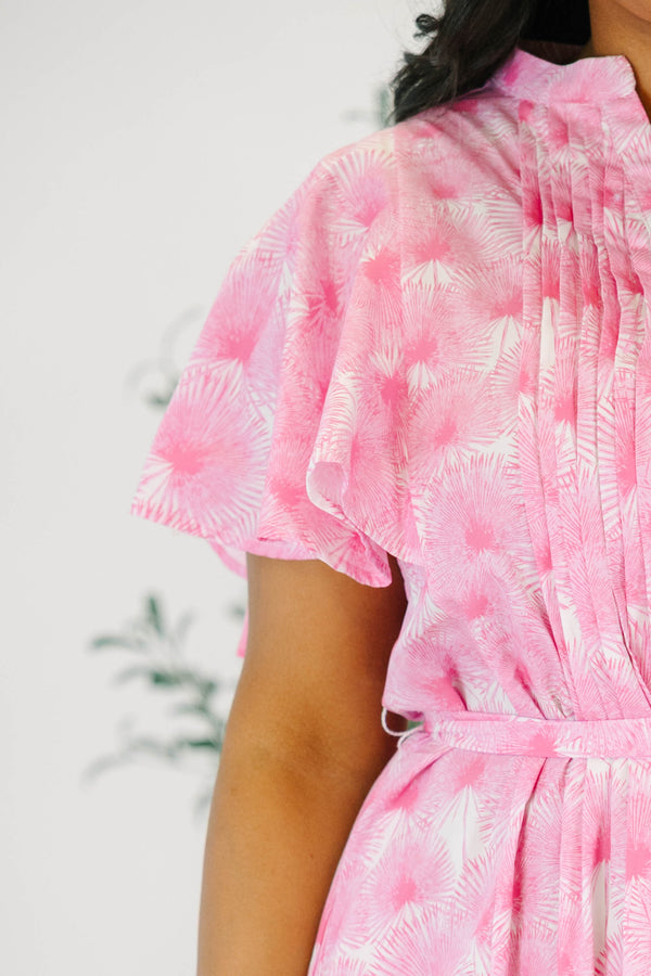 Plus size pink floral midi dress with ruffle sleeves, a tie waist, and flowy tiered skirt.