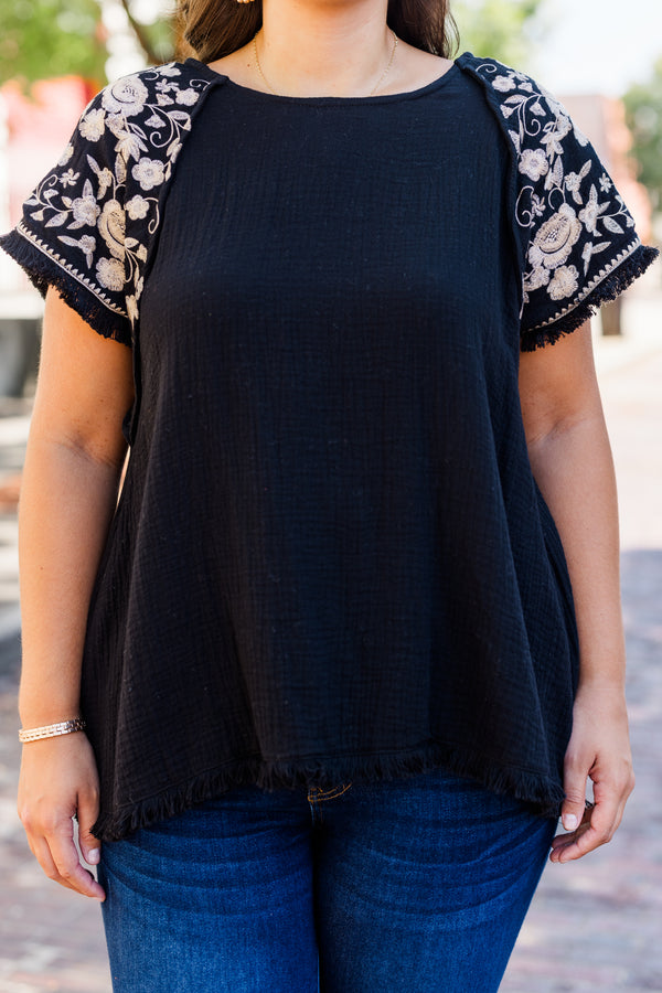 Chic Soul plus size clothing, black linen short sleeve top with round neckline and white embroidery along sleeves with raw hem detail