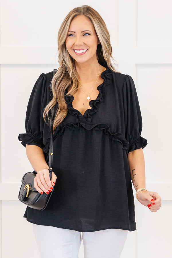 Plus Size black top with a ruffled v-neckline and elastic ruffle sleeves.