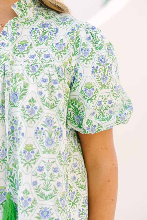Chic Soul plus size clothing, green top with bubbles that has a multi colored floral block pattern and two tassels hanging from the ruffle collar 
