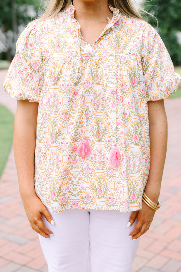 Plus Size pink floral print top with puff sleeves, a ruffled neckline, and tassel details.