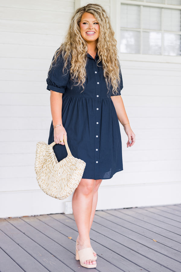 Plus Size navy blue babydoll dress with short puff sleeves, a collared neckline, and button front.