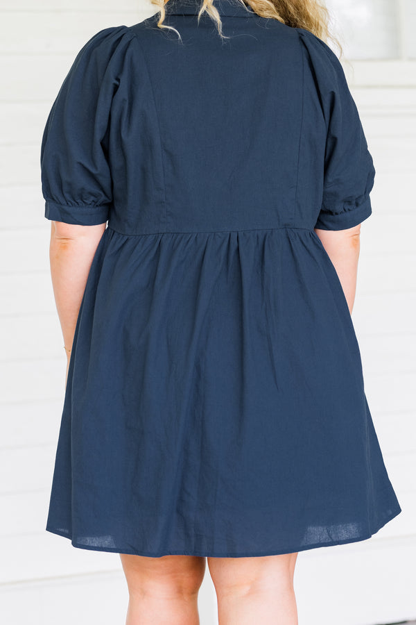 Plus Size navy blue babydoll dress with short puff sleeves, a collared neckline, and button front.
