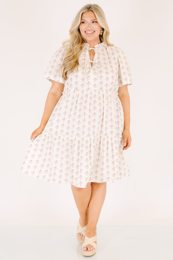 Chic Soul plus size clothing, cream tiered knee length dress with a pink floral pattern as well as two bows that tie  on the across the v-neckline 