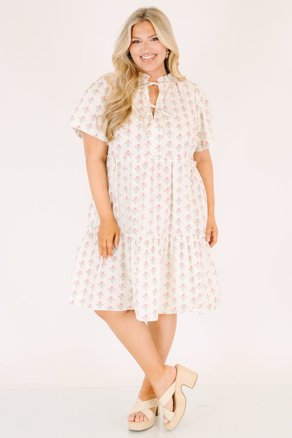 Chic Soul plus size clothing, cream tiered knee length dress with a pink floral pattern as well as two bows that tie  on the across the v-neckline 