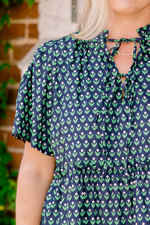 Chic Soul plus size clothing, navy floral baby doll dress that has short sleeves and a floral block pattern throughout as well has two bows that tie across the v-neckline 
