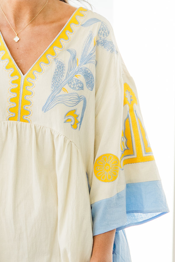 Chic Soul plus size clothing, white short sleeve mini sundress with v neckline with blue detail along bottom of sleeves with blue along the sides with yellow/blue embroidery along chest