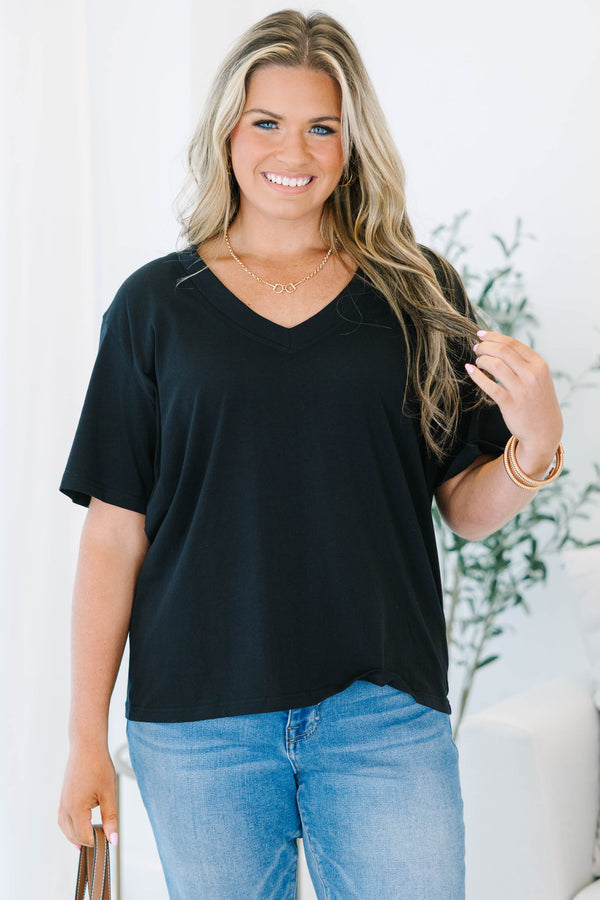 Plus Size black short sleeve V-neck t-shirt with a relaxed fit, paired with blue jeans.
