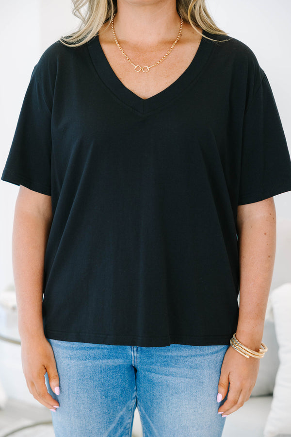 Plus Size black short sleeve V-neck t-shirt with a relaxed fit, paired with blue jeans.