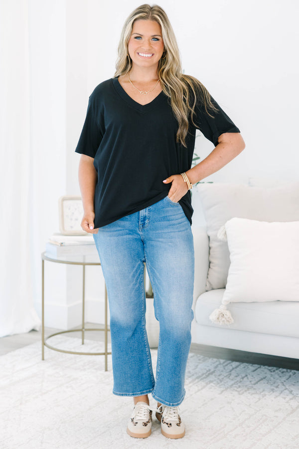 Plus Size black short sleeve V-neck t-shirt with a relaxed fit, paired with blue jeans.