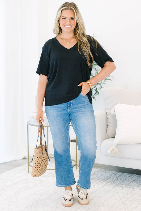 Plus Size black short sleeve V-neck t-shirt with a relaxed fit, paired with blue jeans.