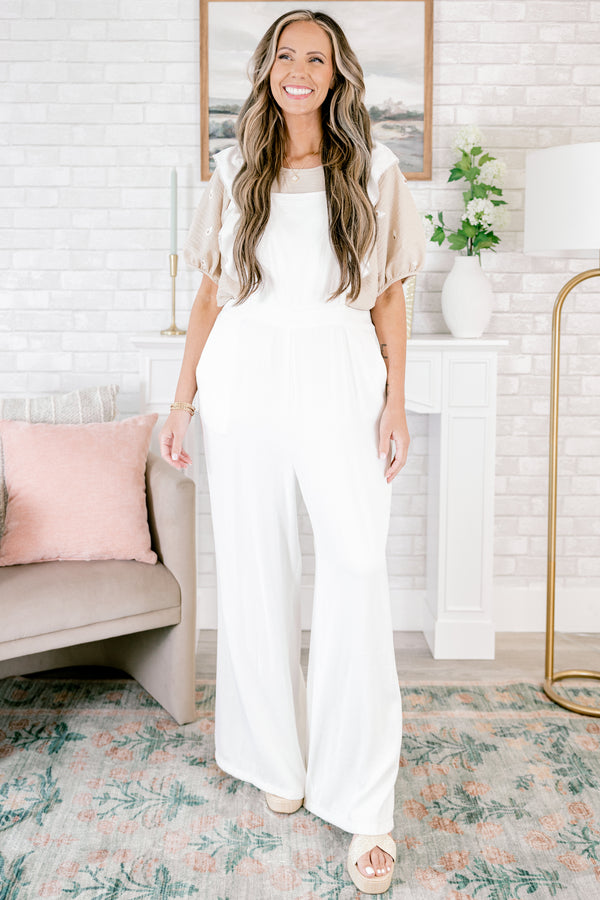 Plus Size white wide-leg jumpsuit with adjustable straps and frayed flutter sleeve details.