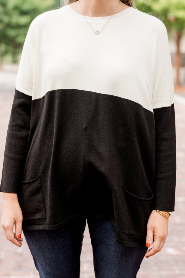 Plus Size ivory and black colorblock sweater with a crew neck, long sleeves, and front pockets.