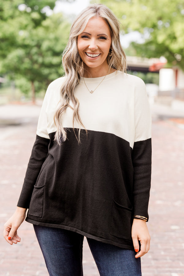 Plus Size ivory and black colorblock sweater with a crew neck, long sleeves, and front pockets.