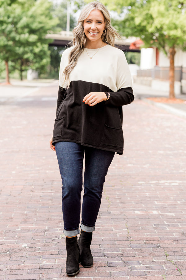 Plus Size ivory and black colorblock sweater with a crew neck, long sleeves, and front pockets.