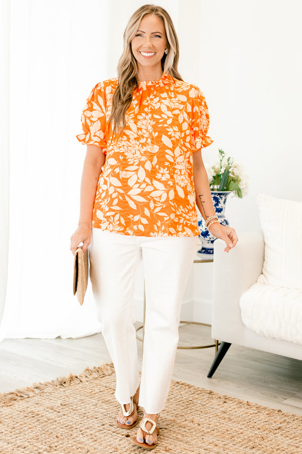 Chic Soul plus size clothing, orange top with a white floral pattern and bubble sleeves that have small ruffle detailing on the ends 