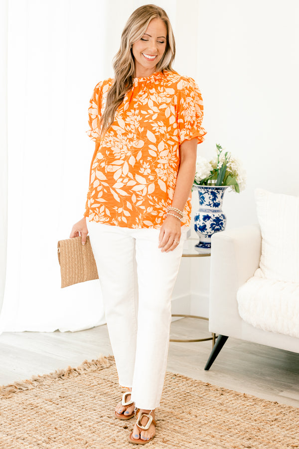 Chic Soul plus size clothing, orange top with a white floral pattern and bubble sleeves that have small ruffle detailing on the ends 