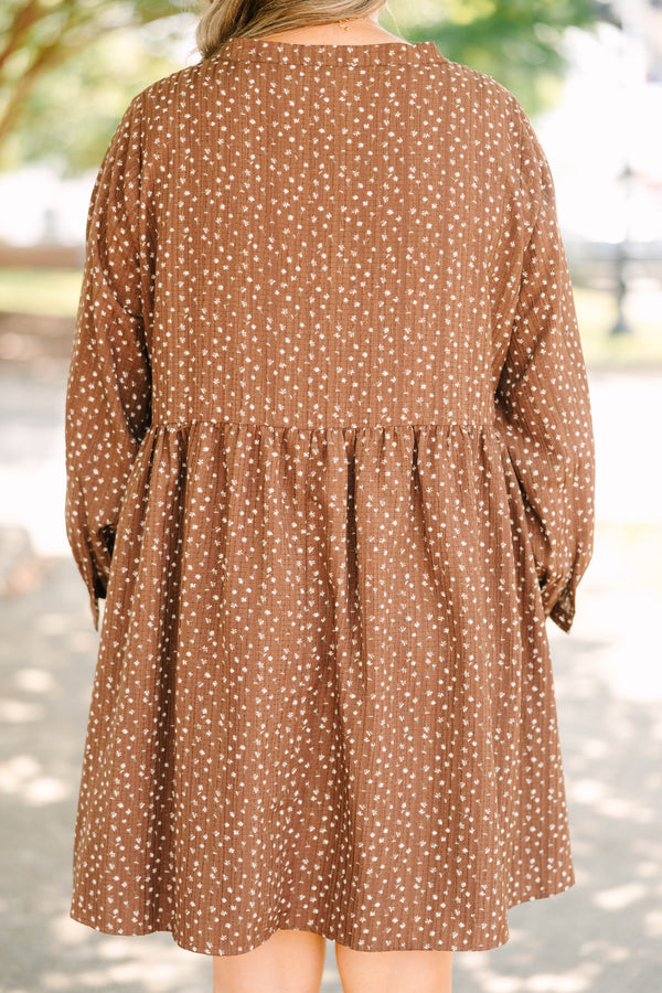 Plus Size brown long-sleeve mini dress with a white floral print, buttoned V-neck, and pockets.