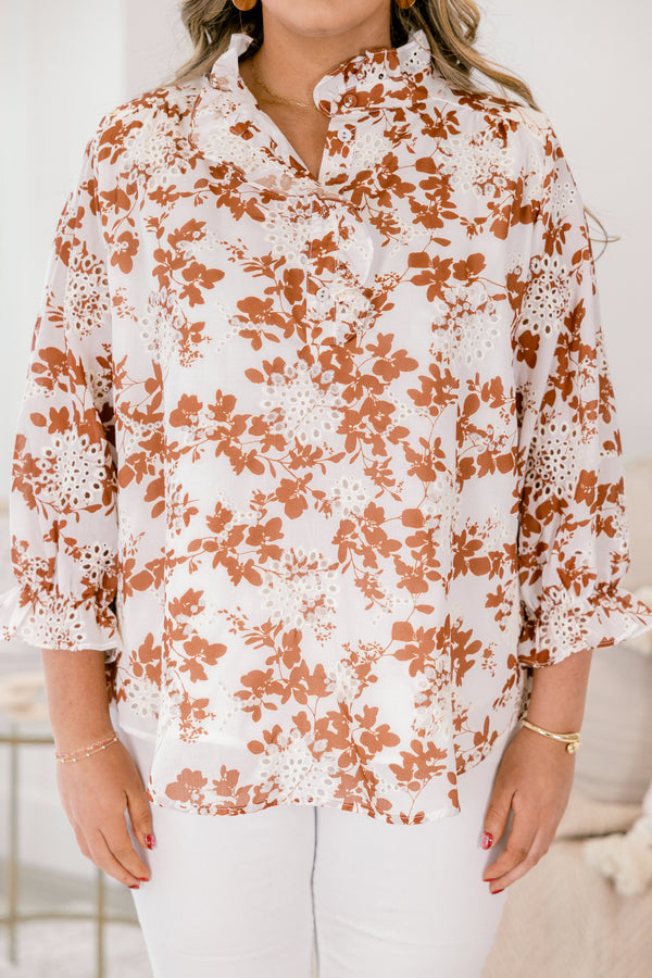 Chic Soul plus size clothing, ivory top with long sleeves that have a ruffle detail at the bottom of each sleeve as well a orange floral pattern and eyelet details throughout the top 