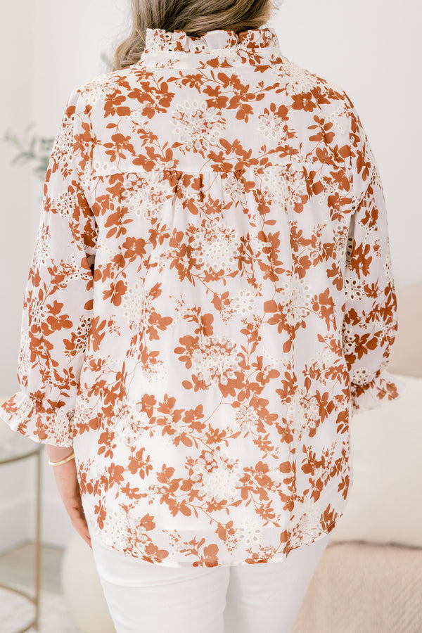 Chic Soul plus size clothing, ivory top with long sleeves that have a ruffle detail at the bottom of each sleeve as well a orange floral pattern and eyelet details throughout the top 