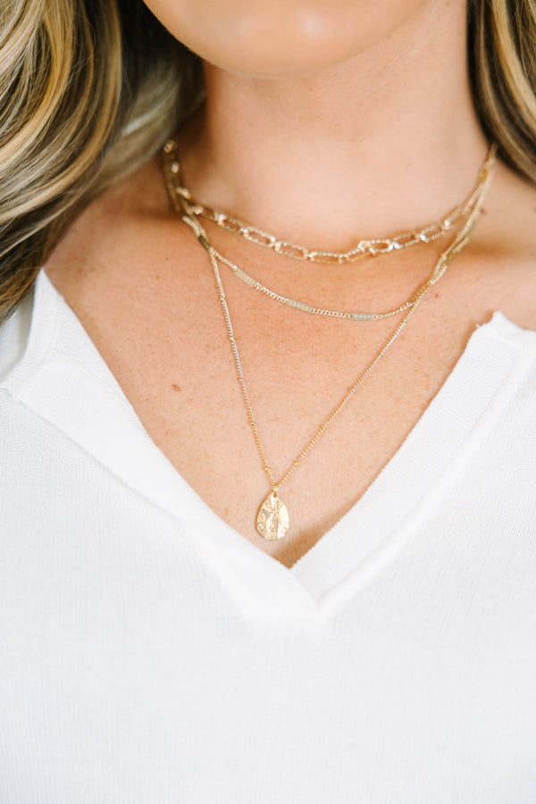 Gold layered necklace with a teardrop pendant.