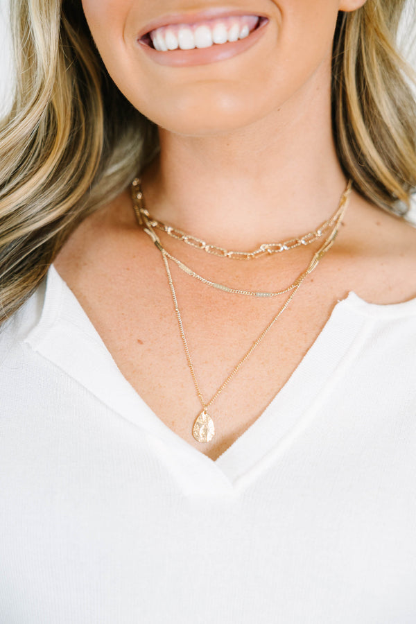 Gold layered necklace with a teardrop pendant.