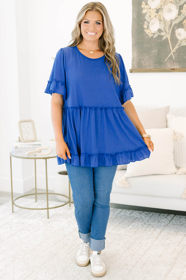 Plus size blue flowy top with ruffle sleeves and a tiered babydoll silhouette in a soft cotton blend