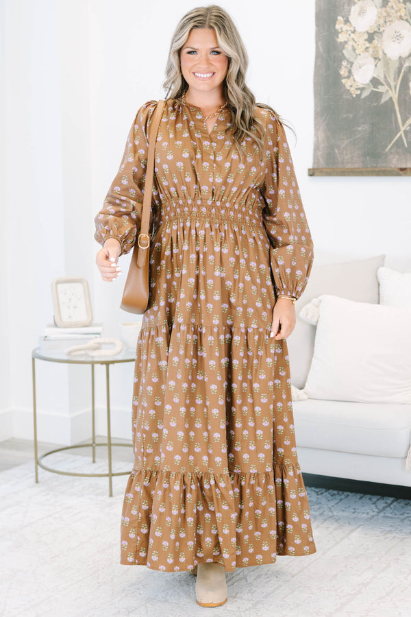 Plus size brown floral maxi dress with a smocked waist, tiered skirt, and long puff sleeves.