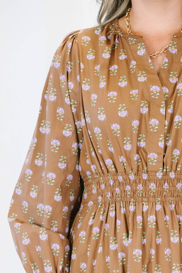 Plus size brown floral maxi dress with a smocked waist, tiered skirt, and long puff sleeves.