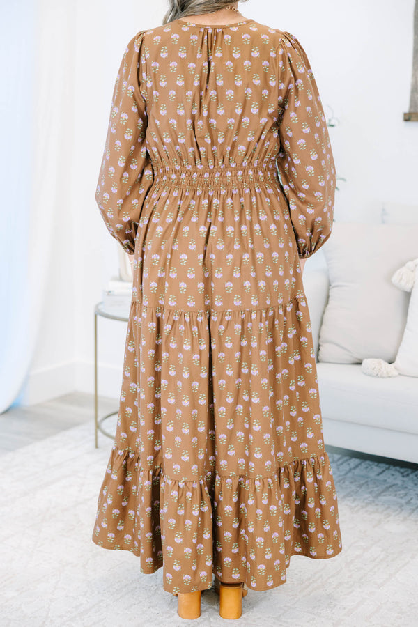 Plus size brown floral maxi dress with a smocked waist, tiered skirt, and long puff sleeves.