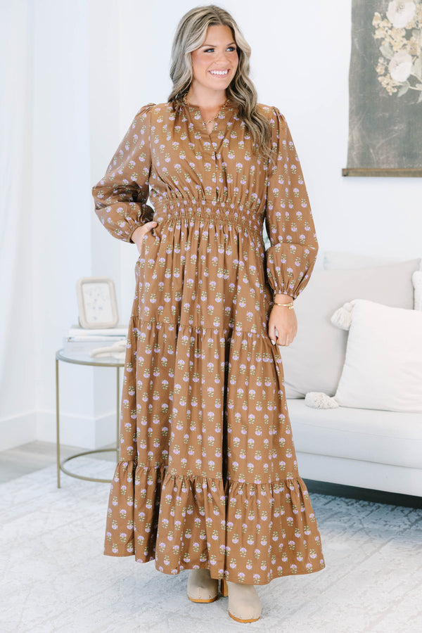 Plus size brown floral maxi dress with a smocked waist, tiered skirt, and long puff sleeves.