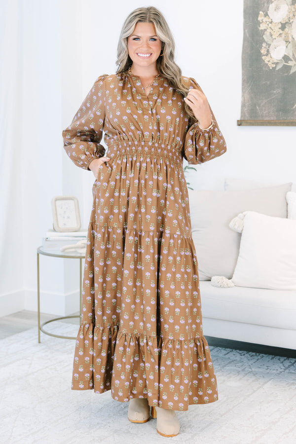 Plus size brown floral maxi dress with a smocked waist, tiered skirt, and long puff sleeves.